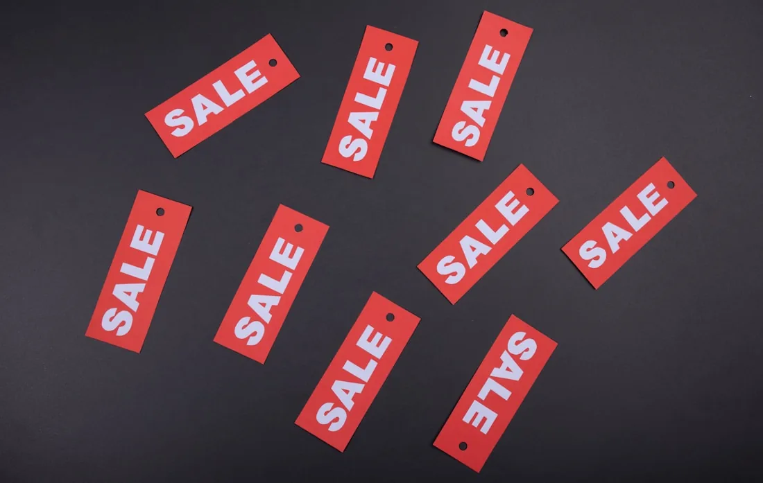Sale tags laid out on a dark surface