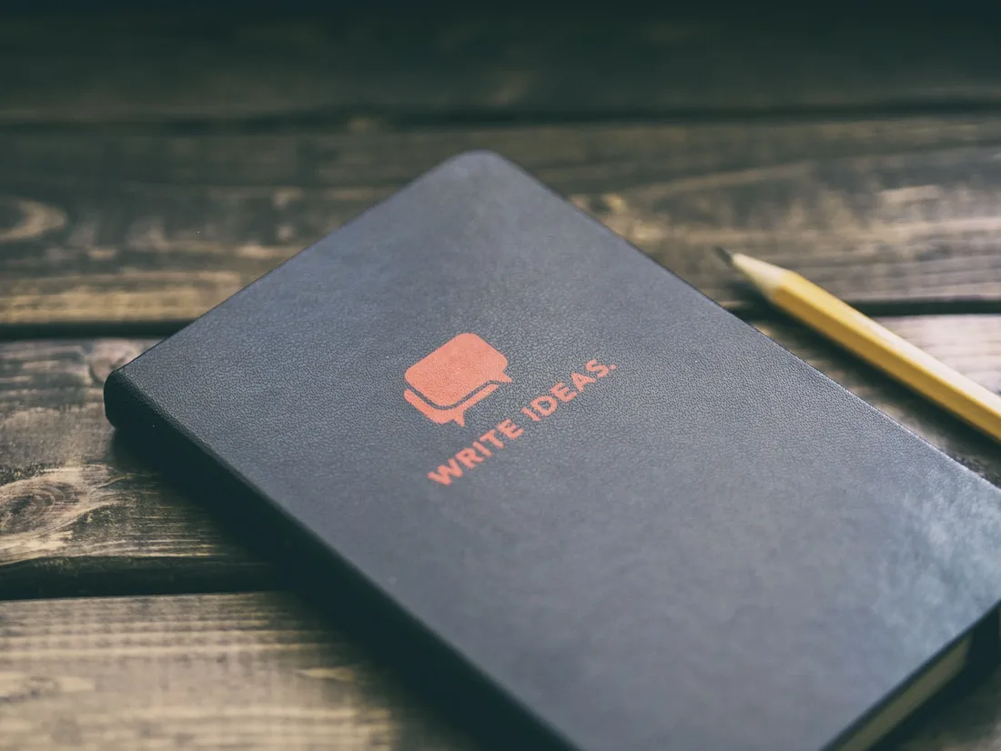 A notebook reading write ideas beside a pencil